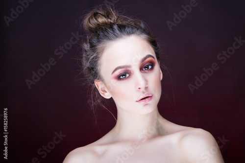 Wonderful woman portrait. Fashionable and stilish make-up. Red background.