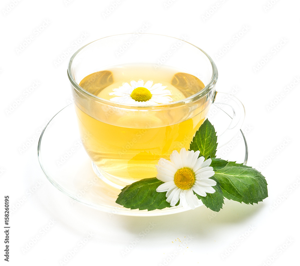Transparent cup of chamomile tea with flowers and mint leaf