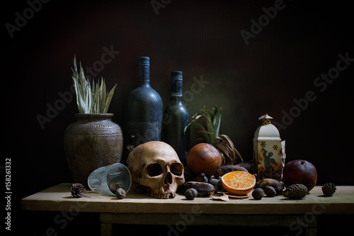 Skull and objects expired and dried and rotten fruits on the plank in dim light night / Still life style  and select focus, space for text.