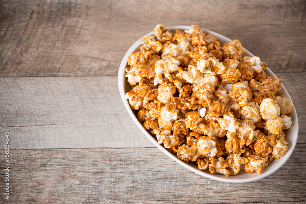 Caramel opcorn in bowl on the wooden table. Caramel opcorn in bowl on the wooden table.