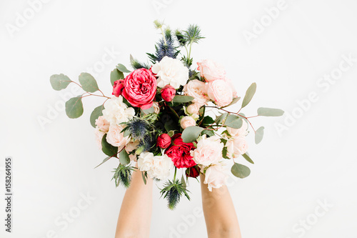 Foto Girl's hands holding beautiful flowers bouquet: bombastic roses, blue eringium, eucalyptus, isolated on white background