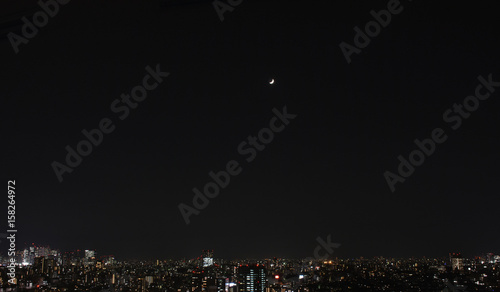 夜空に見える月・日本の東京都市景観（左側に新宿の高層ビル群）