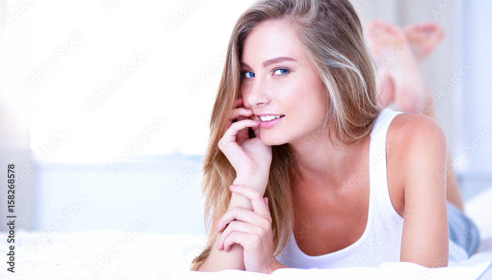 Pretty woman lying down on her bed at home Pretty woman lying down on her bed at home