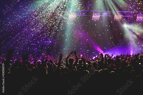 View of rock concert show in big concert hall, with crowd and stage lights, a crowded concert hall with scene lights, rock show performance, with people silhouette © tsuguliev