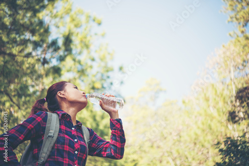 Close up of young hiker drinking water at mountain.