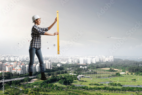 Builder woman taking measures photo