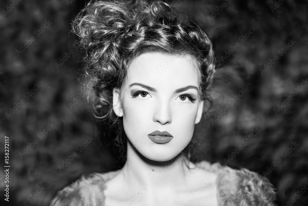 beautiful girl with curly hair in fur coat. Black and white photo