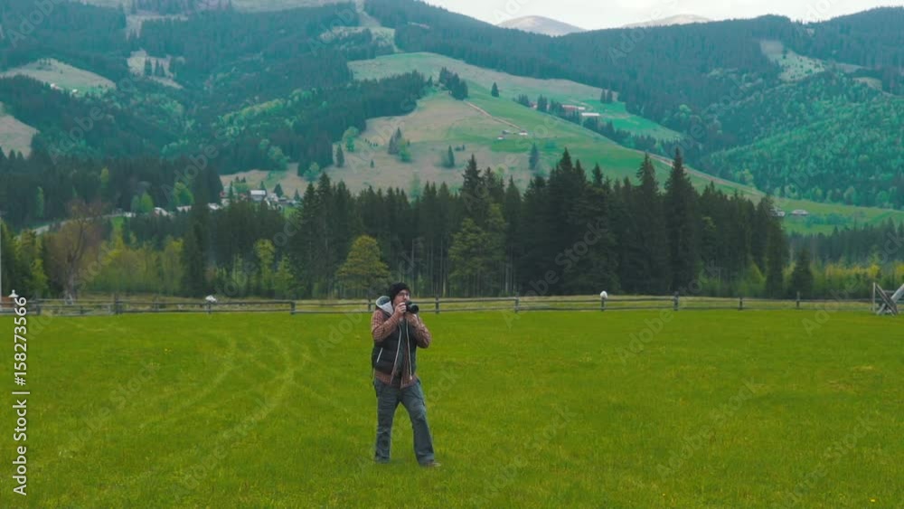 Photographer takes a photo in the green valley. Photographer takes a photo in the green valley.