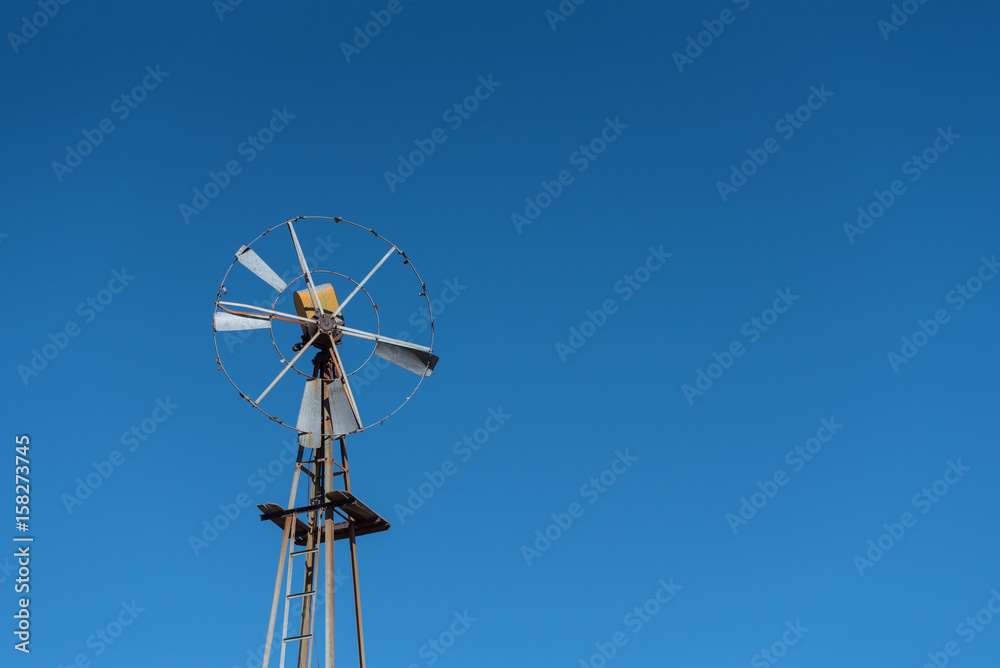 Rusted Windmill in the Desert on Blue Sky Rusted Windmill in the Desert on Blue Sky