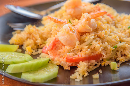 Fried rice with shrimp on the dish on wooden table