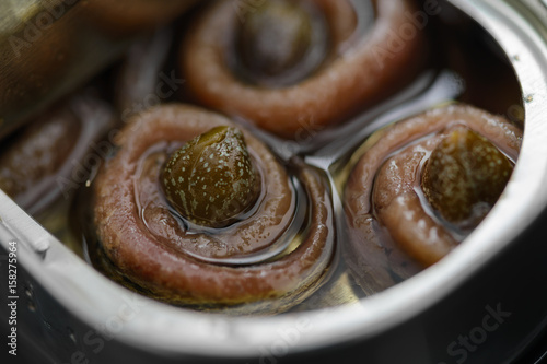 Anchovy rolls with capers in olive oil in tin. Close up photo