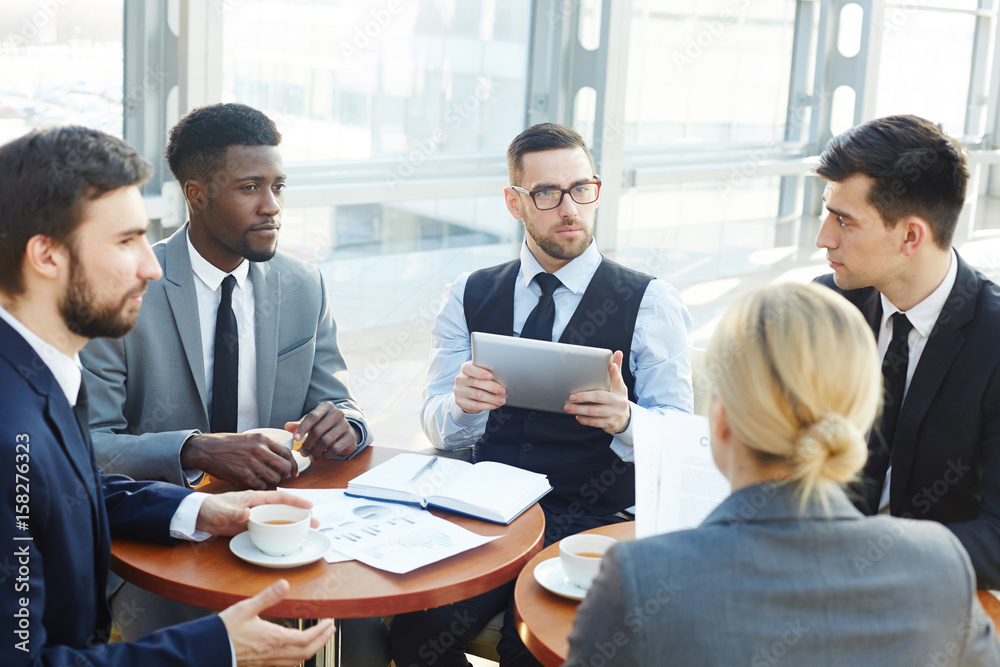 Group of employees discussing financial information Group of employees discussing financial information