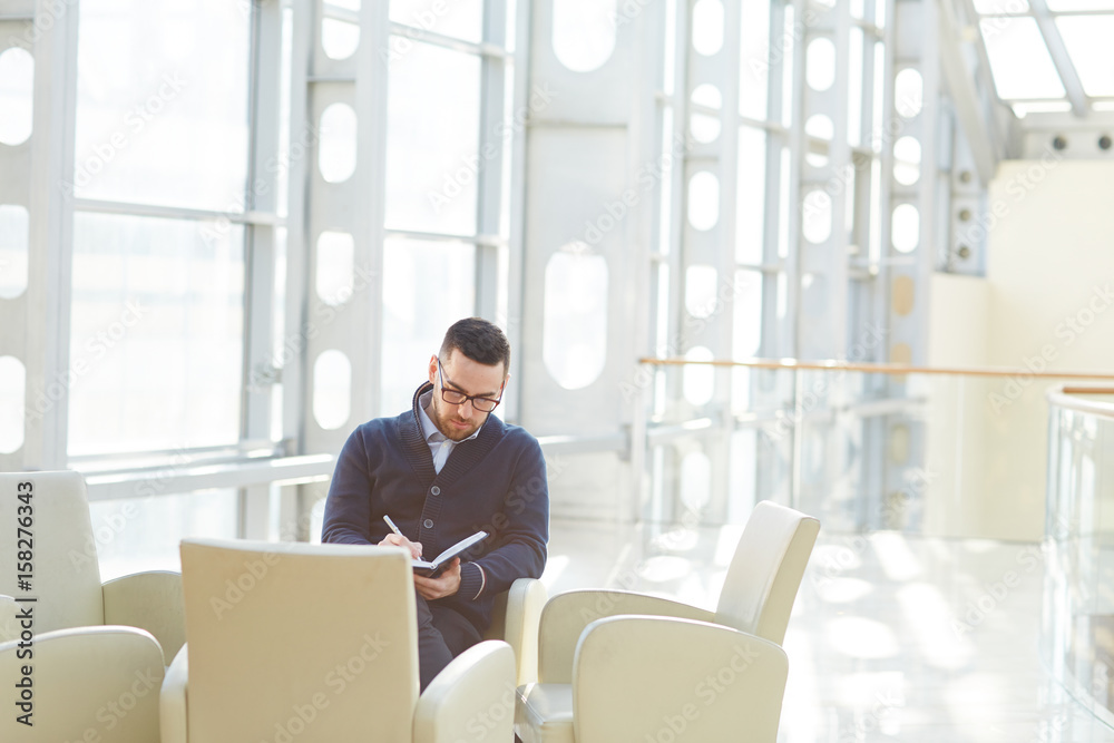 Businessman making notes in notebook