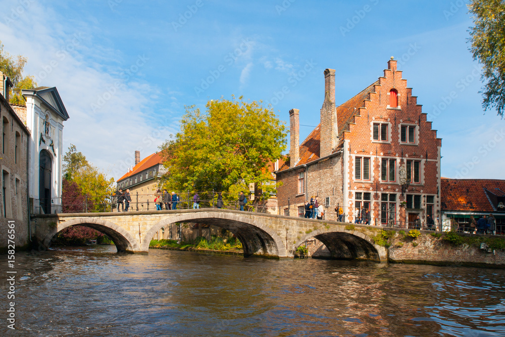 Water canal with old bridge and medieval houses at Begijnhof, Bruges, Belgium.
