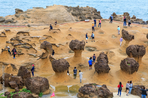 Tourists at the Yeliu (Yehliu) Geopark in Wanli District, New Taipei, Taiwan at a rainy, windy and overcast day photo