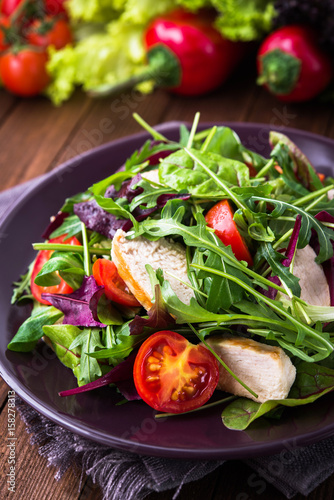 Wallpaper Mural Fresh salad with chicken, tomatoes and mixed greens (arugula, mesclun, mache) on wooden background close up. Healthy food. Torontodigital.ca