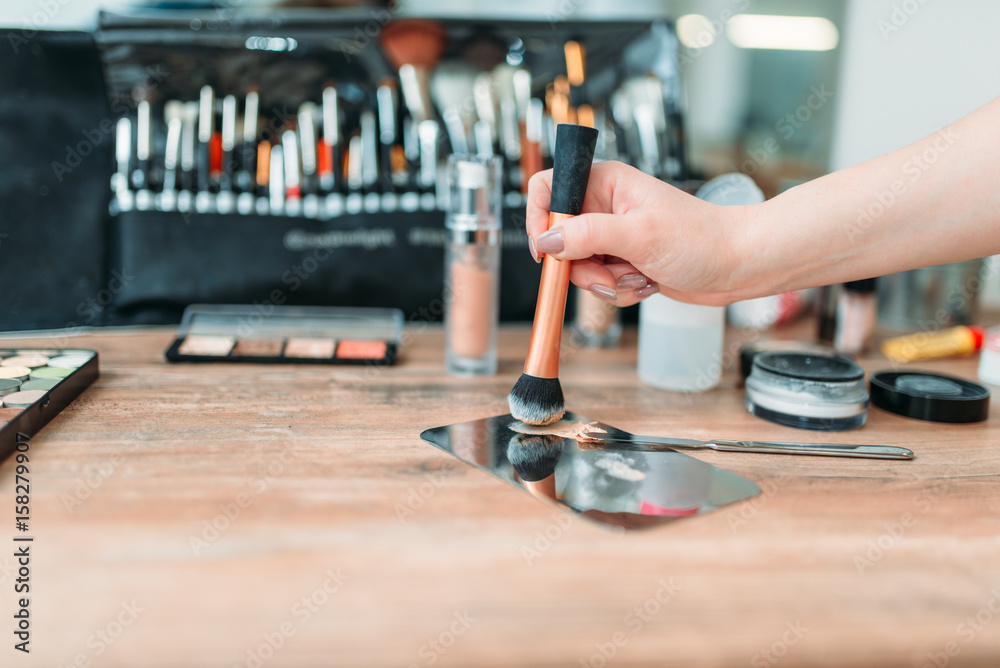 Make up artist hand with brush prepares cosmetics