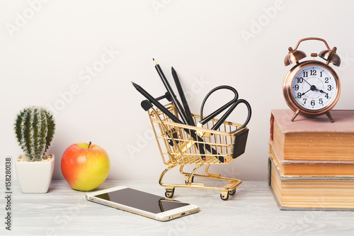 Back to school modern background with book, alarm clock and smartphone photo