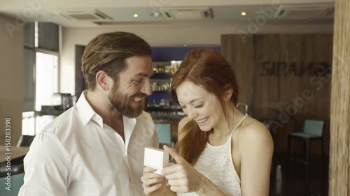 Man giving girlfriend engagement ring photo