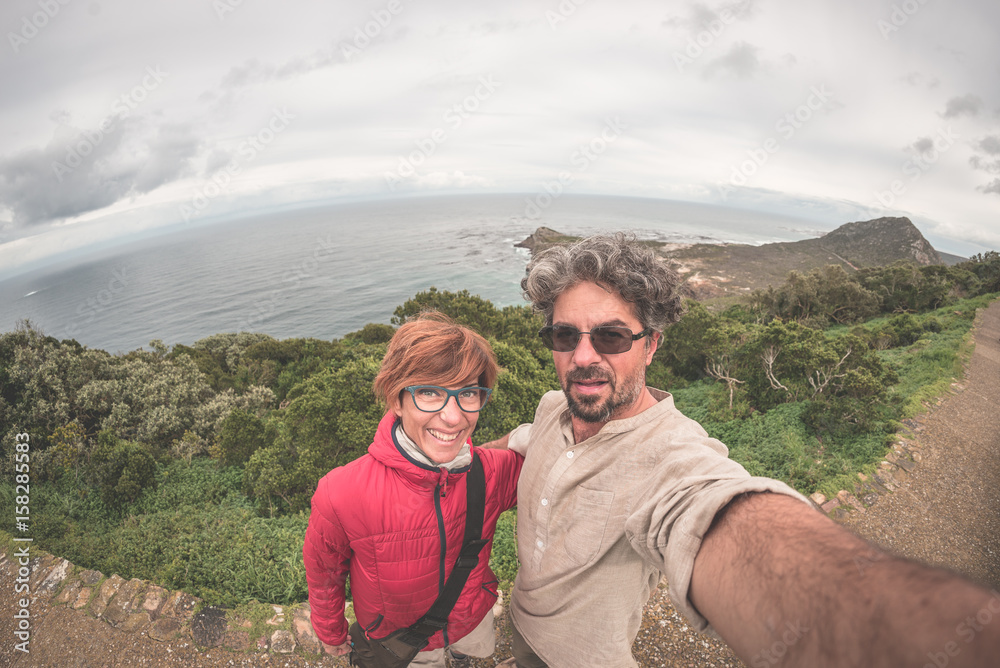 Couple taking selfie at Cape Point, Table Mountain National Park, scenic travel destination in South Africa. Fisheye view from above.