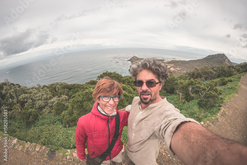Couple taking selfie at Cape Point, Table Mountain National Park, scenic travel destination in South Africa. Fisheye view from above.