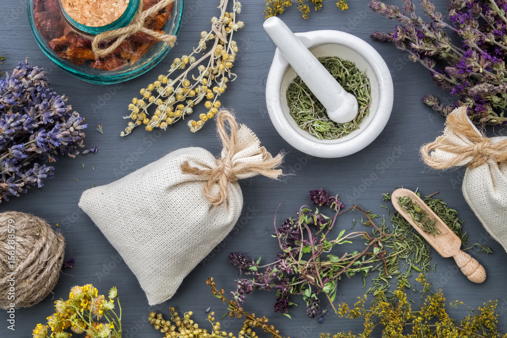 Medicinal herbs, mortar of healing herbs, sachet and bottle of healthy drugs on wooden table. Herbal medicine. Top view, flat lay. - obrazy, fototapety, plakaty 