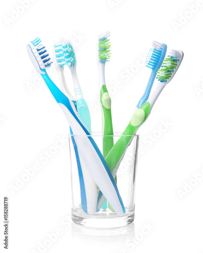 Toothbrushes in glass on white background