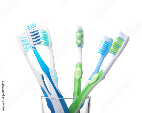 Toothbrushes in glass on white background