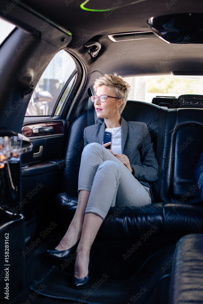 Business woman in limo sitting