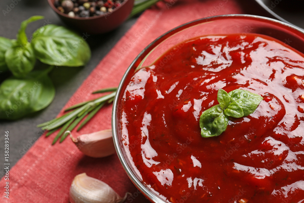 Delicious ketchup in bowl with ingredients, closeup Delicious ketchup in bowl with ingredients, closeup