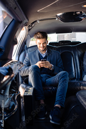 Businessman texting in limo