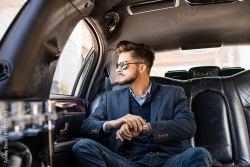 Businessman with shades in limousine