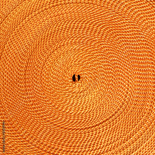 Orange fabric texture with a spiral pattern converging towards the center