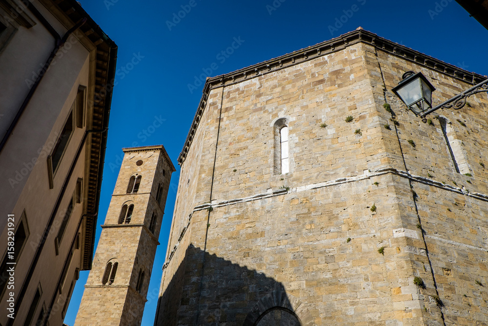 VOLTERRA, TUSCANY - MAY 21, 2017 - Baptistery of San Giovanni Battista and tower of Cathedral VOLTERRA, TUSCANY - MAY 21, 2017 - Baptistery of San Giovanni Battista and tower of Cathedral