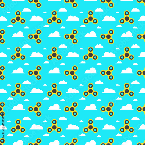 Spinner. A pattern of yellow spinners in a flat style. Spinners are spinning against the sky. Flat, white clouds. A modern antistress toy for recreation. Play with your fingers
