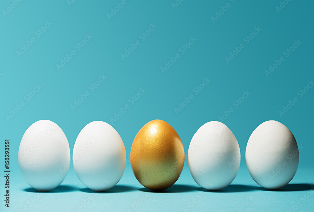 Concept of individuality, exclusivity, better choice. One golden egg among white eggs on blue background. - obrazy, fototapety, plakaty 