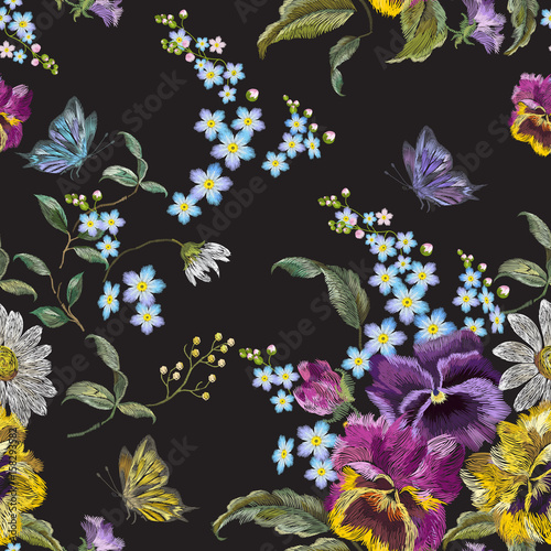 Embroidery floral seamless pattern with pansies, chamomiles and forget me not flowers. Vector traditional embroidered template with butterfly for clothing design.