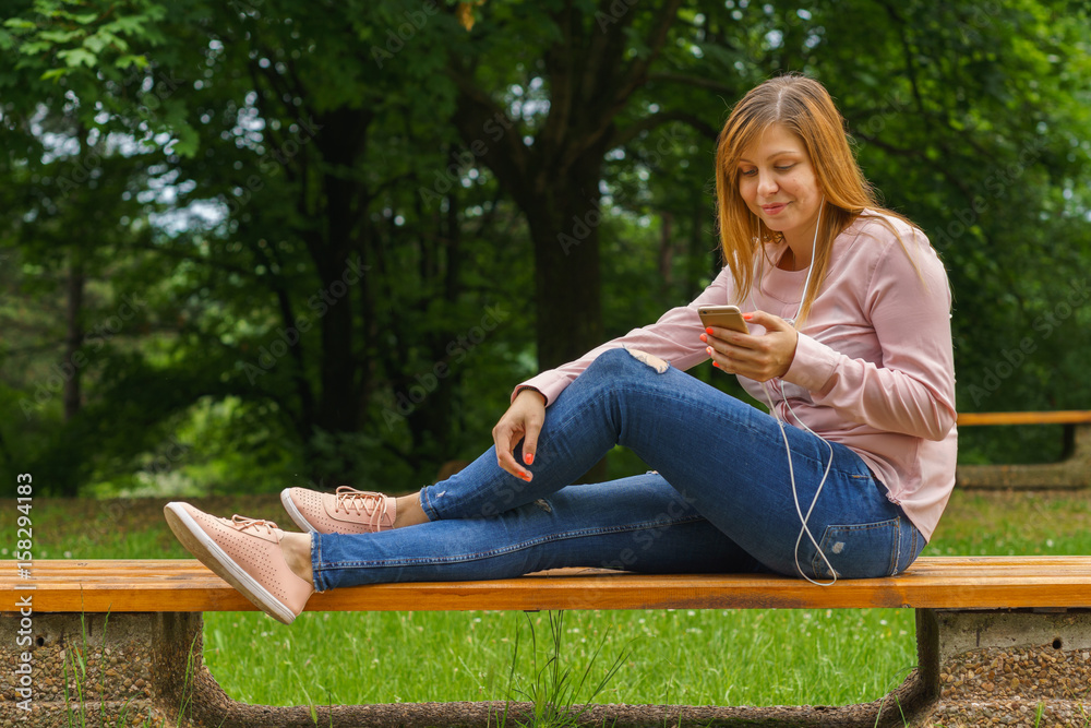 Young woman texting on smart phone outdoors Young woman texting on smart phone outdoors