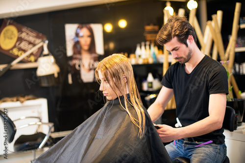 Young male hairdresser with client