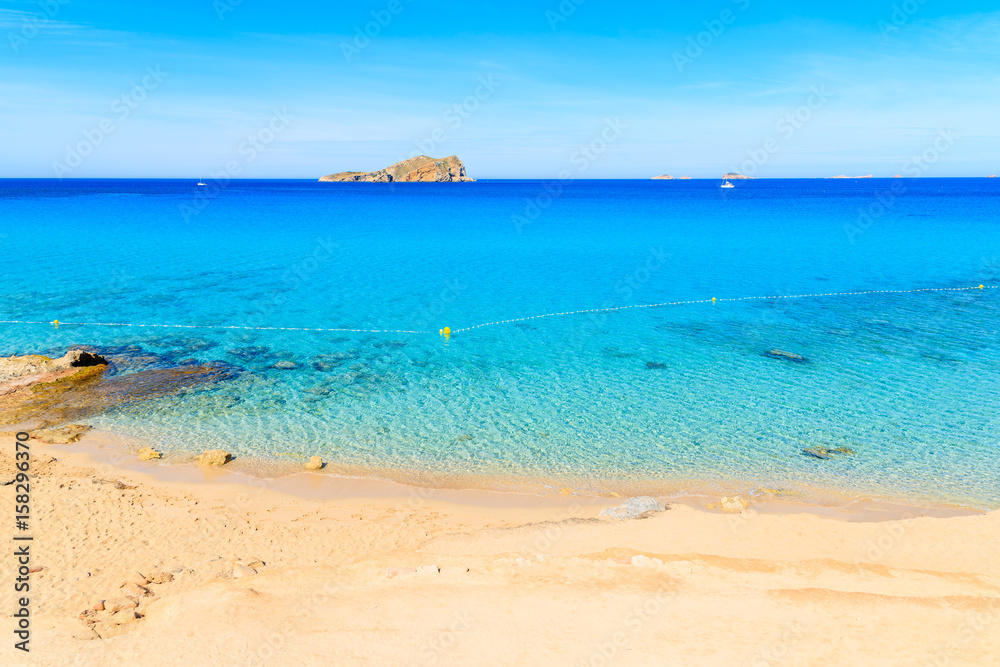 View of beautiful Cala Comte beach famous for its azure crystal clear shallow sea water, Ibiza island, Spain