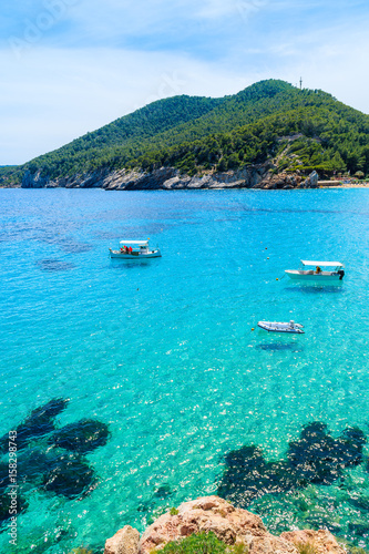 Fishing boats on turquoise sea water in Cala San Vicente bay, Ibiza island, Spain