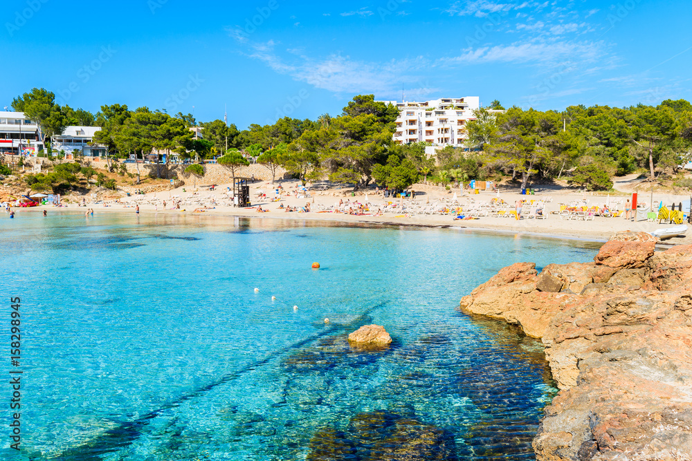 View of beach with azure sea water in Cala Portinatx bay, Ibiza island, Spain