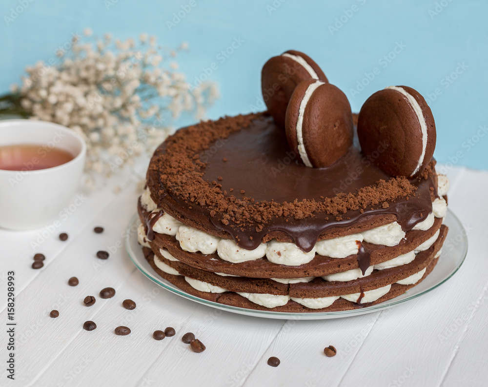 Chocolate cake on a white wooden table. Blue background. Chocolate cake on a white wooden table. Blue background.