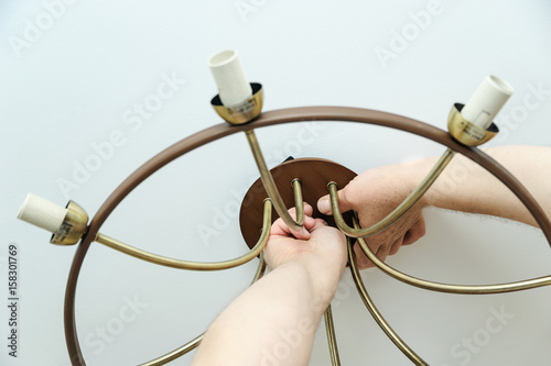 Electrician is installing and connecting a lamp.