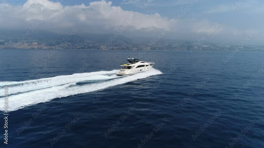 Aerial lateral view of a luxury yacht navigating fast close to the Ligurian coast. Aerial lateral view of a luxury yacht navigating fast close to the Ligurian coast.