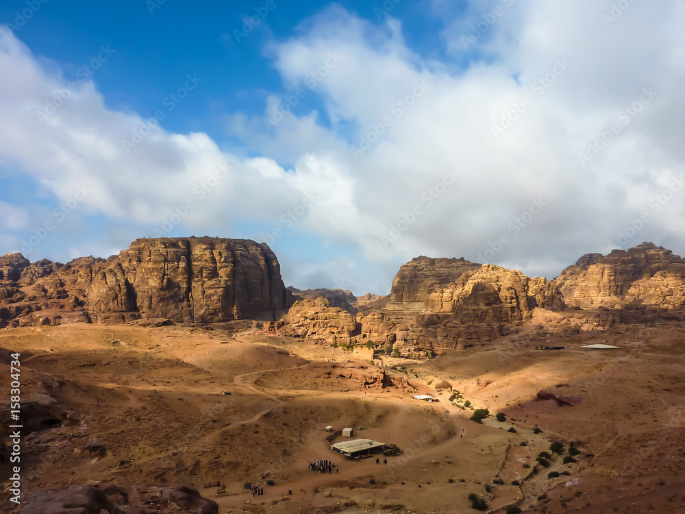 PETRA, JORDAN, NOV 25, 2011: Panoramic view of a red rose rock formation against a blue sky in Petra (Rose City)