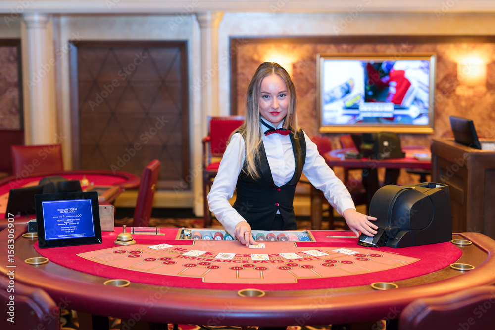 Obraz premium Cute lady casino dealer at Black Jack table.