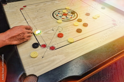 A game of carrom with pieces carrom man on the board carrom
