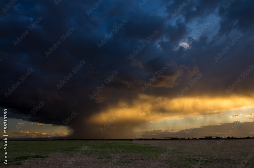 Light from the sunset illuminates falling rain near the mountains in Colorado. Light from the sunset illuminates falling rain near the mountains in Colorado.