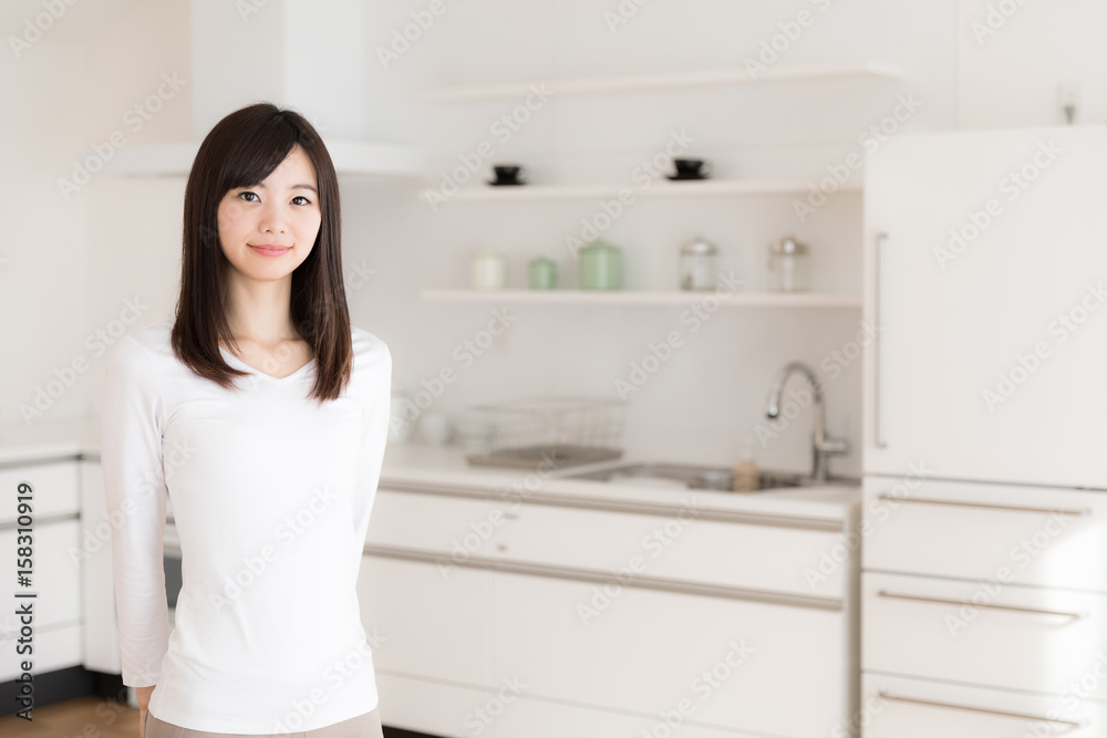 attractive asian woman relaxing in kitchen